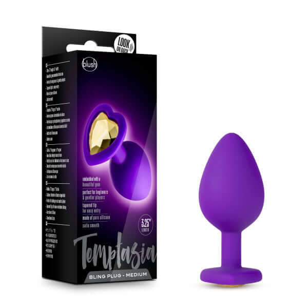 Temptasia Bling Plug Medium in sparkling purple with heart-shaped base and gold faux gemstone, packaging visible in background
