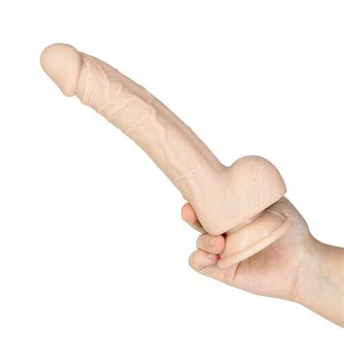 Hand holding the Naked Addiction Tristan 9-inch realistic silicone dildo with lifelike design and balls.