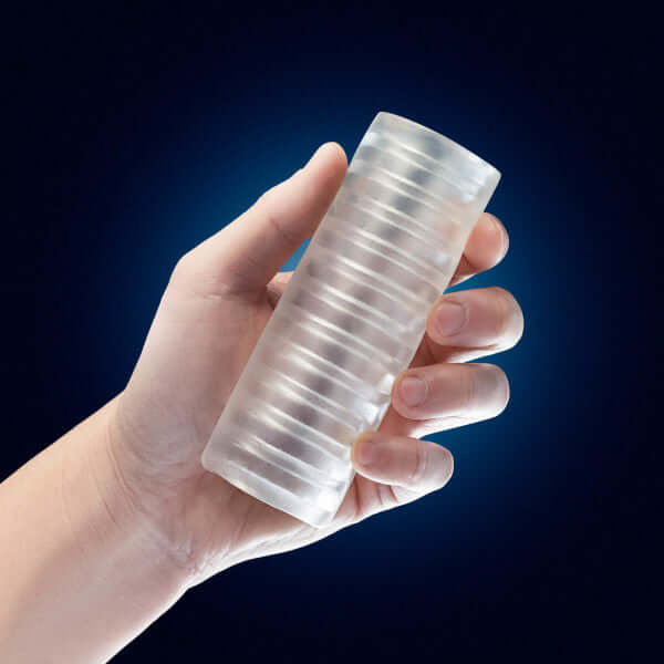 Rize Ribz Glow In The Dark Self Lubricating Stroker Clear held in hand displaying ribbed texture by Blush Novelties