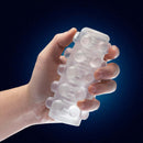 Hand holding Rize Swich Glow In The Dark Self Lubricating Stroker Clear from Blush Novelties with soft ticklers and ribbed inside.