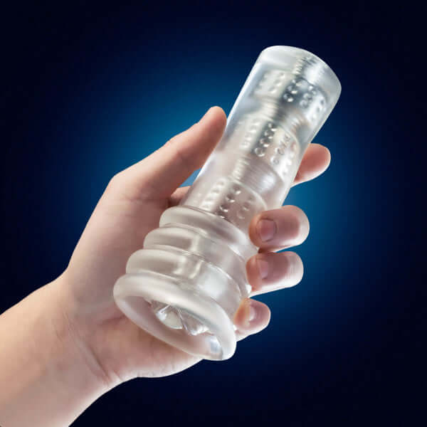Hand holding Rize Luz Glow-In-The-Dark Self-Lubricating Stroker against dark background