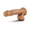 Dr. Skin Dr. Mark 7 inches dildo with balls in tan medium skin tone with suction cup base from Blush Novelties lies on a smooth surface.