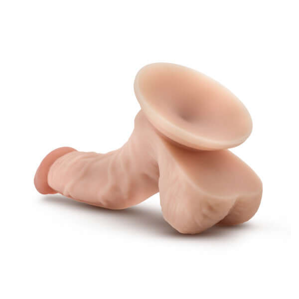 Dr. Skin Dr. Stephen 6.5-inch beige dildo with balls and suction cup base from Blush Novelties laying on a white background