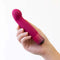 Hand holding Oh My Gem Classy Garnet Red Vibrator for internal and external exploration, enhancing pleasure and removing negative energy.