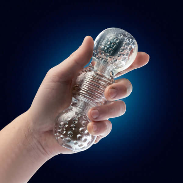 Hand holding Rize Feelz Clear Male Masturbator with textured translucent compartments for enhanced pleasure from Blush Novelties.