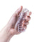 Hand holding Rize Squeezy Clear Male Masturbator from Blush Novelties featuring multi-textured chambers and clear design.