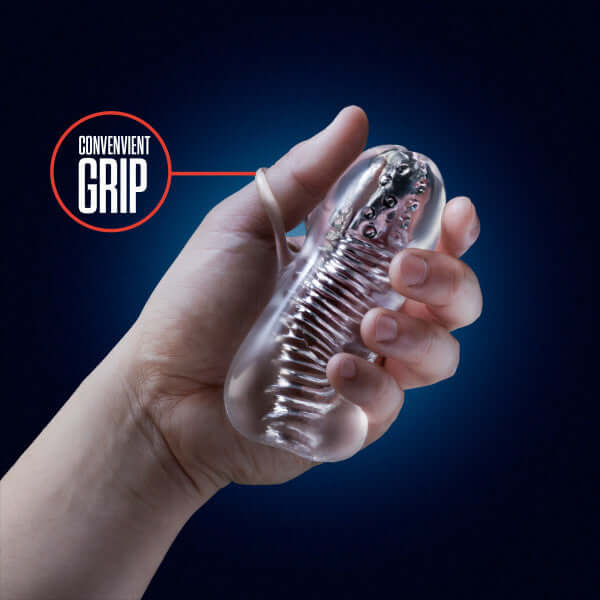 Hand holding the Rize Squeezy Clear Male Masturbator from Blush Novelties with convenient grip feature highlighted.