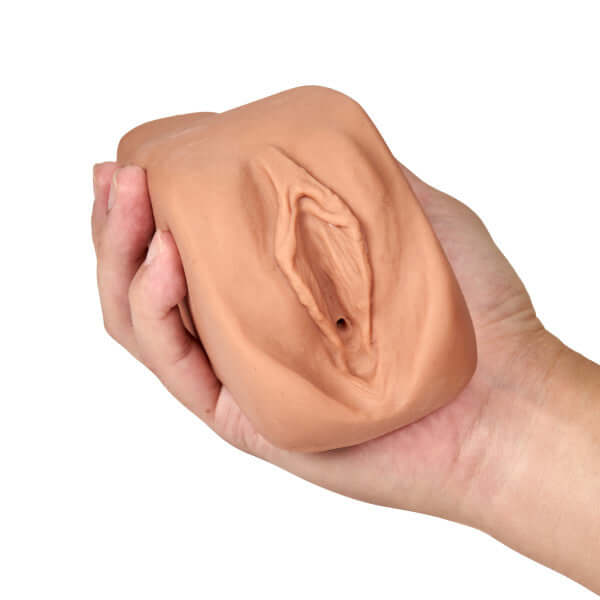 M Elite Soft and Wet Renata Tan Male Masturbator held in hand, showcasing realistic textured design for enhanced pleasure.