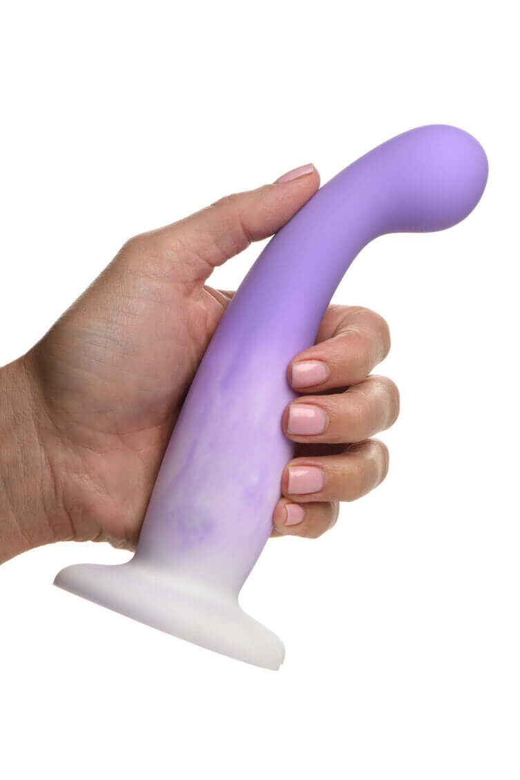 Hand holding Simply Sweet Slim G-Spot Silicone Dildo in purple and white, showcasing sleek, slender design for targeted G-spot stimulation.