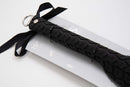 Large black Sei Mio Tyre Spanking Paddle with textured handle and ribbon detail on packaging. Perfect for dynamic sensations.