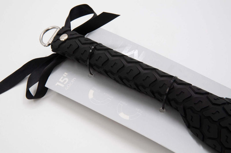 Large black Sei Mio Tyre Spanking Paddle with textured handle and ribbon detail on packaging. Perfect for dynamic sensations.