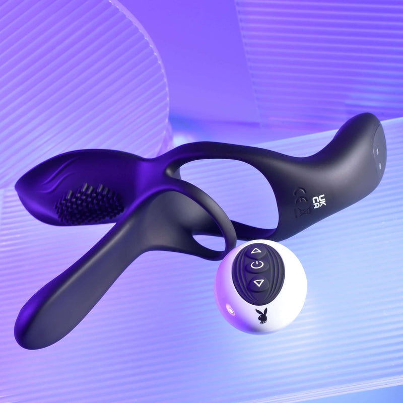 Playboy The 3 Way Vibrating Cock Ring set on a lighted background showcasing its innovative design and remote control.