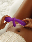 Woman holding purple JimmyJane G-Rabbit Vibrator near her abdomen for G-spot and clitoral stimulation.