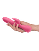 Pink JimmyJane Glo Rabbit Heating Vibrator in hand showing flexible design and clitoral stimulator.