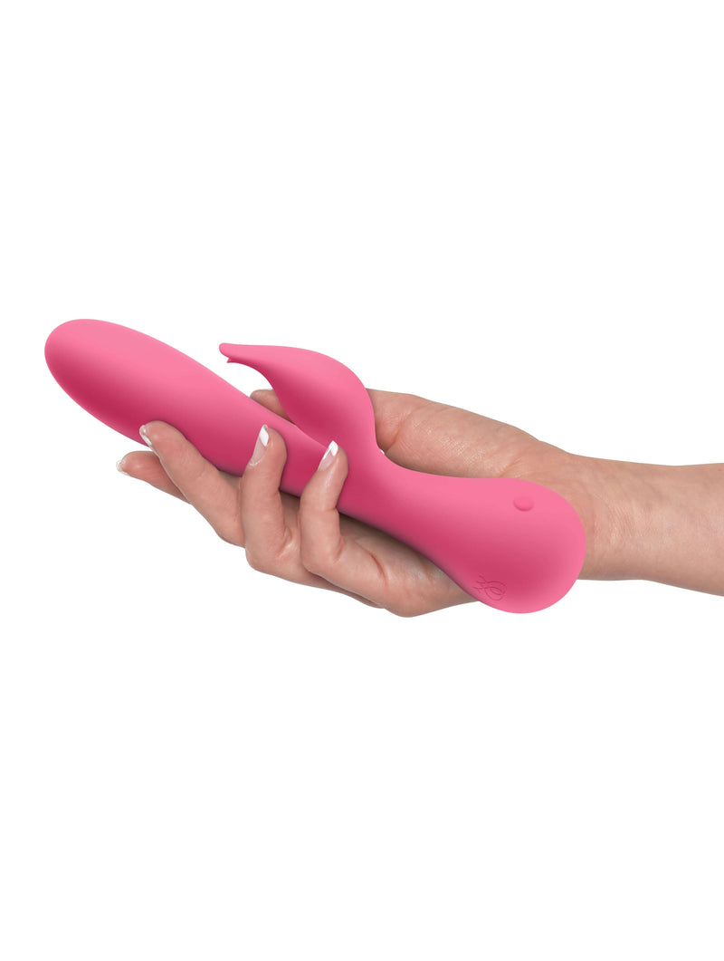 Pink JimmyJane Glo Rabbit Heating Vibrator in hand showing flexible design and clitoral stimulator.