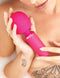 Woman holding the vibrant pink JimmyJane Exona Body Wand in a relaxing setting.