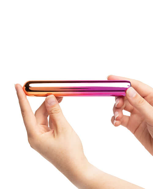 Person holding Sensuelle Aluminum Rumba Double Motor Ombre Multicolor Vibrator in hand