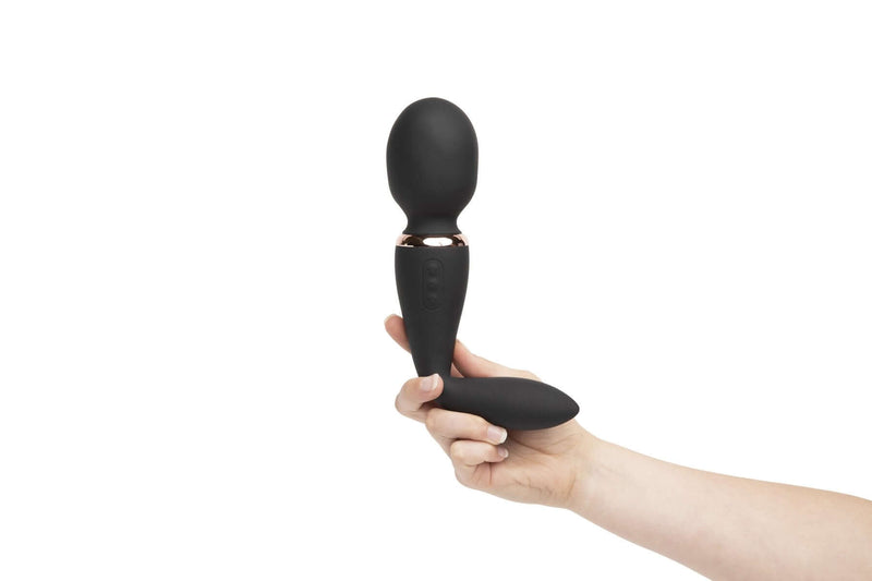 Hand holding Sensuelle Alluvion Wand Black with two powerful motors and dual ended for clitoral, G-Spot, and anal stimulation.