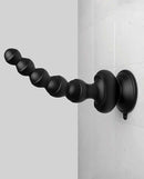 Threesome Wall Banger Beads vibrating massager with suction cup base attached to a tiled wall.
