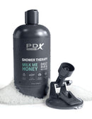 PDX Plus Shower Therapy Milk Me Honey Stroker disguised as shampoo bottle with attachments on white foamy surface.