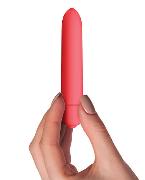 Sugarboo Coral Crush Bullet Vibrator held in hand, showcasing its sleek design and vibrant coral color for sensual pleasure.