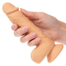 Hand holding 5-inch Dual Density Silicone Stud Dildo with suction cup base in light ivory skin tone from California Exotic Novelties.