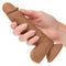 Hand holding Dual Density Silicone Stud Dildo 5 inches Brown with suction cup base.