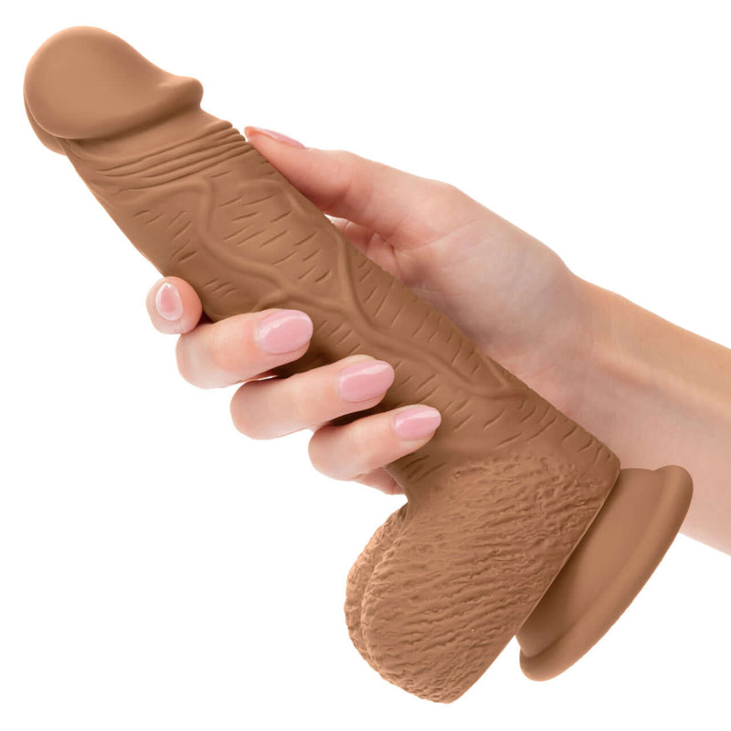 Brown Dual Density Silicone Dildo 6.25 inches with suction cup base held in hand
