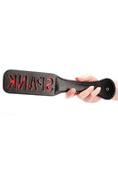 Hand holding the Paddle Spank Black with reversed 'SPANK' imprint, made from durable faux leather.