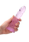 Pink non-realistic dildo with suction cup for anal and vaginal use held in hand - 7 inches from Shots Toys America