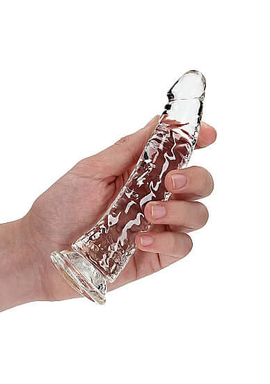 Hand holding a clear, slim 6-inch transparent dildo designed for anal and vaginal use with a suction cup base.