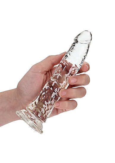 Hand holding Realrock Slim Dildo 7 inches Transparent Clear with lifelike design for anal and vaginal use by Shots Toys.