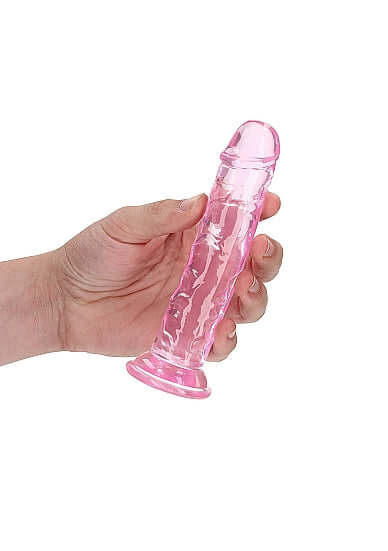 Hand holding Realrock Crystal Clear 6-Inch translucent pink dildo for intimate pleasure by Shots Toys