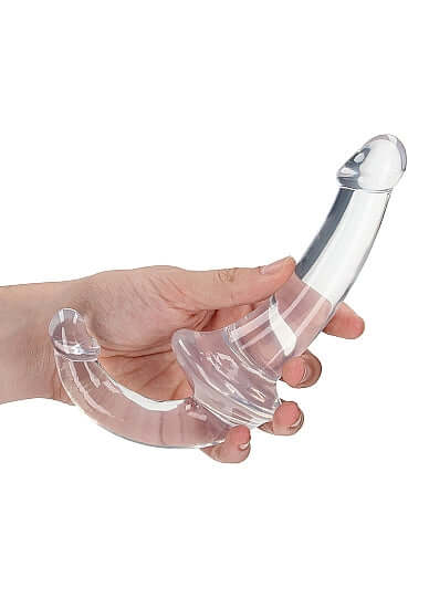 Crystal clear strapless strap-on double dildo held in hand for shared pleasure
