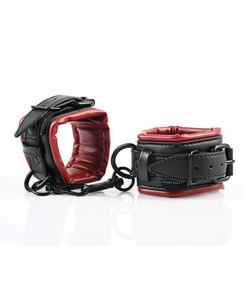 Adjustable faux leather cuffs in red and black for comfortable bondage play with swivel snap clips.