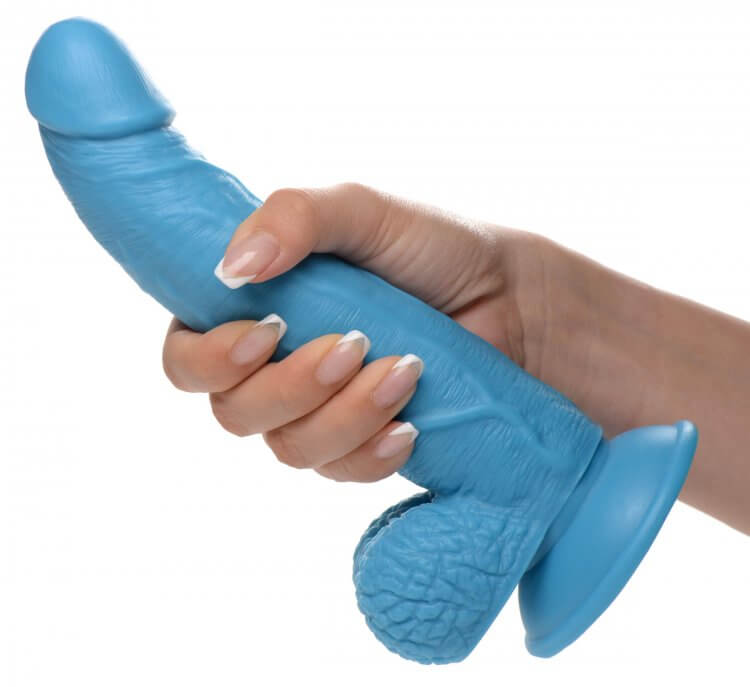Hand holding a Pop 7.5 inches blue dildo with balls and a suction cup base by XR Brands.