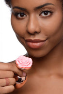 Woman holding Booty Sparks Pink Rose Gold Large Anal Plug with pink flower topper.
