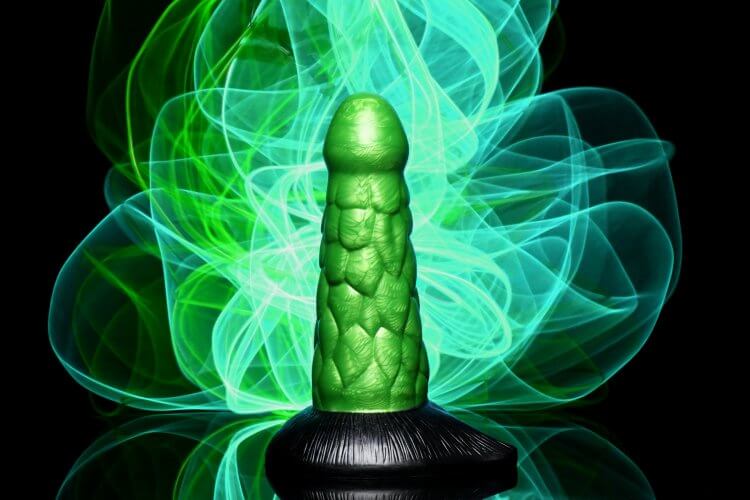 Radioactive Reptile Thick Scaly Dildo in metallic green with black base on glowing green background