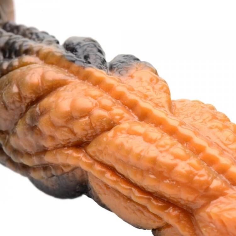 Close-up of Creature Cocks Ravager Rippled Tentacle Silicone Dildo showing detailed rippled texture in marbled red, orange, and brown.