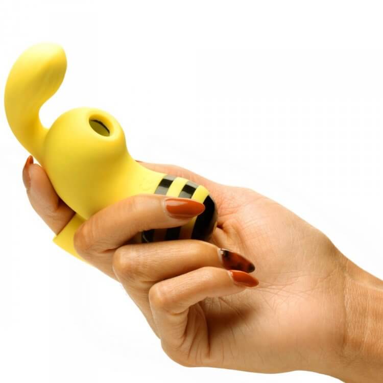 Hand holding the Shegasm Sucky Bee Clit Stimulator Finger Vibe in yellow, showcasing its unique design for pleasure.