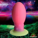Creature Cocks Xeno Glow In The Dark Silicone Egg against an intergalactic background, showcasing its vibrant and captivating alien design.