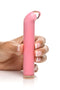 Person holding the Prisms Vibra Glass 10X G-Spot Vibrator in Pink with a golden ring base from XR Brands.