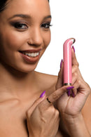 Woman holding Prisms Vibra Glass 10X G-Spot Vibrator in Pink from XR Brands with golden ring at base in close-up.