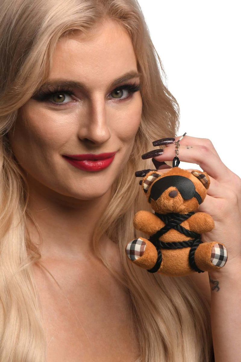 Woman holding the Kinky Bondage Bear Keychain with rope and blindfold, a playful addition to keys, bag, or desk decor.