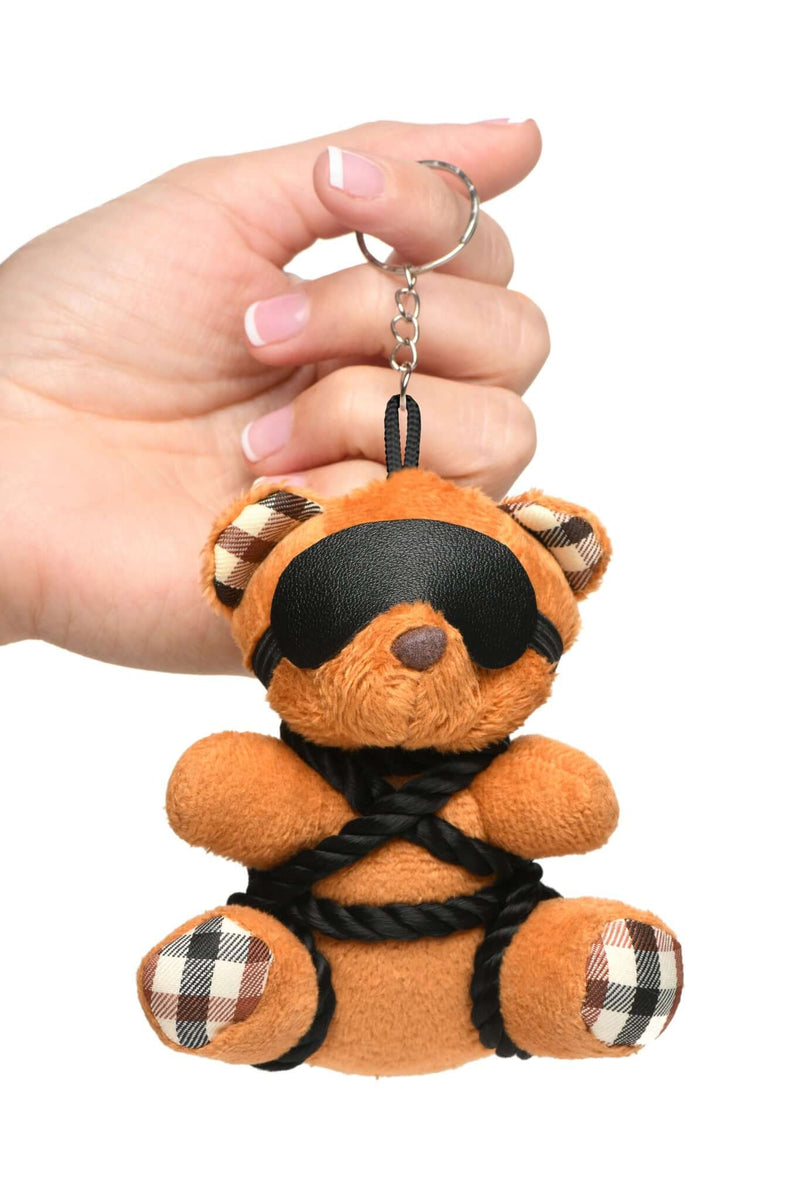 Kinky Bondage Bear Keychain with black silky rope and blindfold, held in hand, perfect for playful desk or backpack accessory.