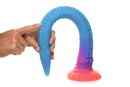 Hand holding Makara glow in the dark silicone snake dildo in blue and pink by Creature Cocks