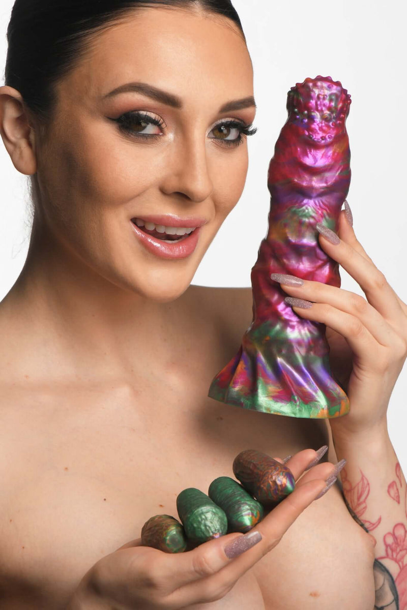Woman holding Creature Cocks Larva Silicone Ovipositor Dildo and colorful eggs.
