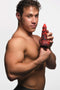 Muscular man holding the Creature Cocks Horny Devil Demon Silicone Dildo by XR Brands against a white background.