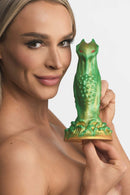 Person holding the Creature Cocks Nebula Alien Galactic Silicone Dildo by XR Brands with green and gold finish and red eyes