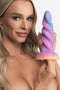 Person holding XR Brands Creature Cocks Moon Rider Glow In The Dark Unicorn Dildo showing vibrant colors and spiral design